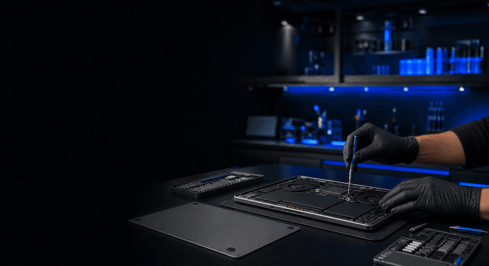 Mãos de um técnico da TERADOT realizando manutenção em um MacBook
